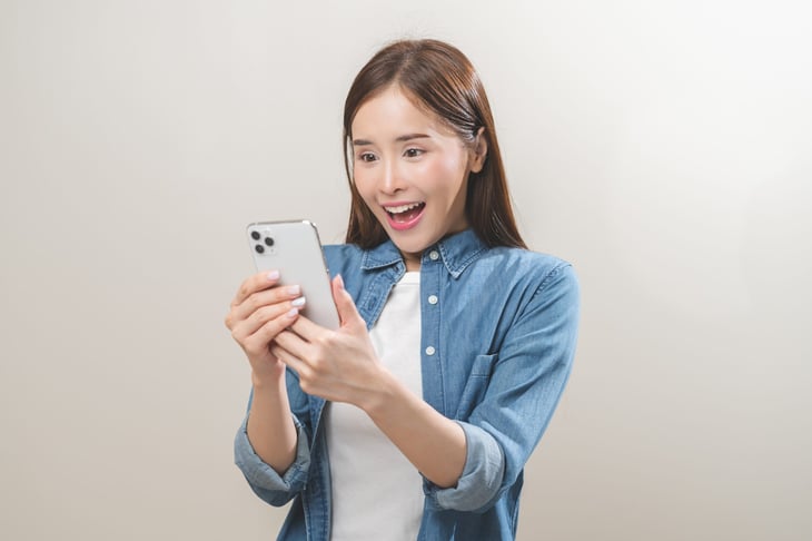 A woman in shock looking at phone.