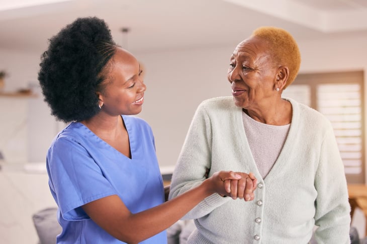 A nurse or caregiver helping a senior woman.