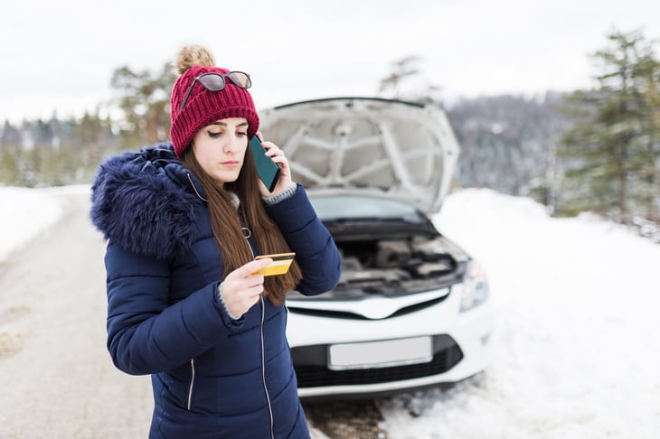 woman with broken down car calling for roadside assistance