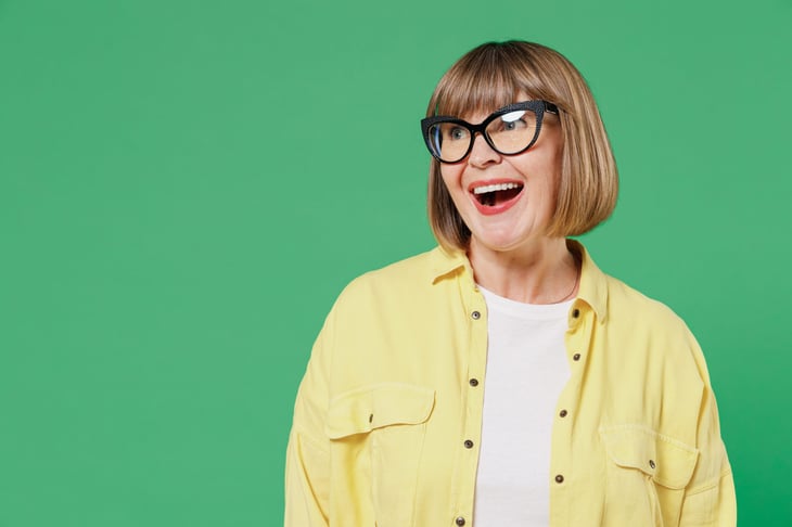 Happy woman in middle age who is surprised or pleased and wearing glasses