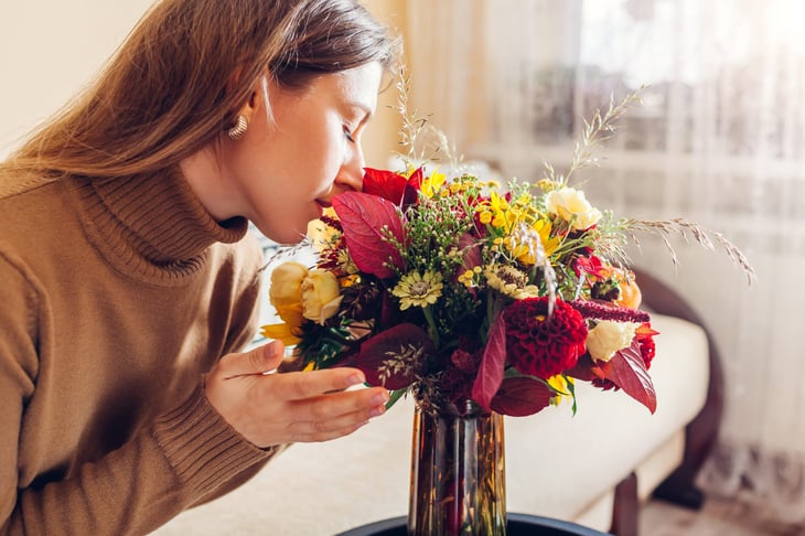 Woman smelling a fall flower bouquet