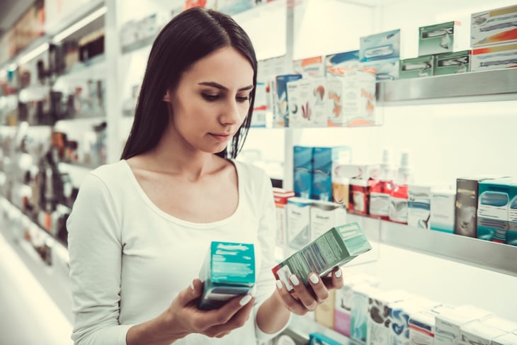 Woman comparing over-the-counter medicine at the pharmacy