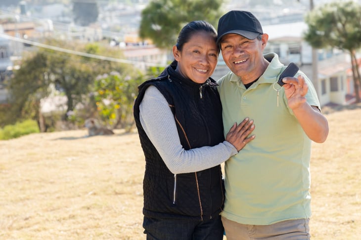 happy homeowners holding up a house key