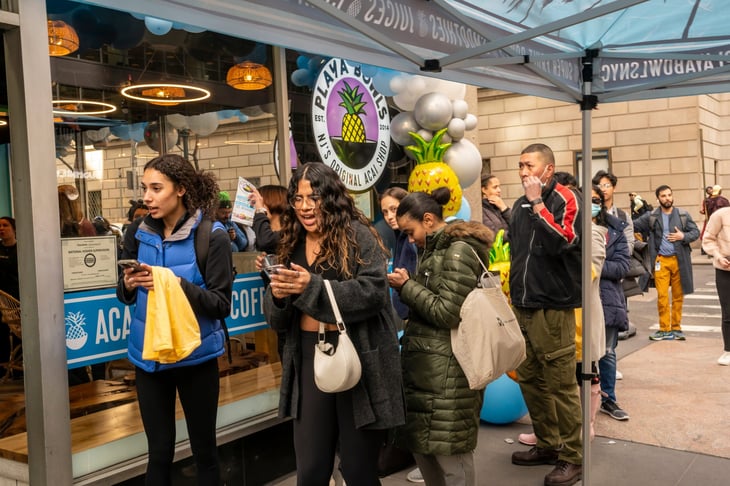 People wait in line for the grand opening of the Playa Bowls chain in Midtown Manhattan