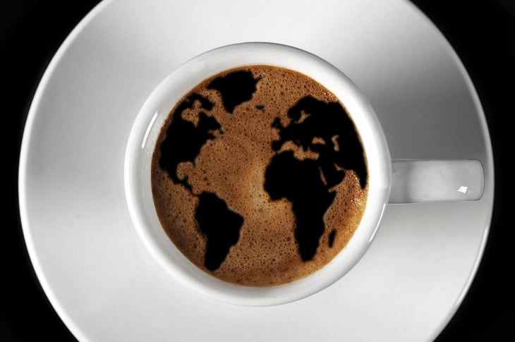 Cup of coffee with an image of the world map in the foam