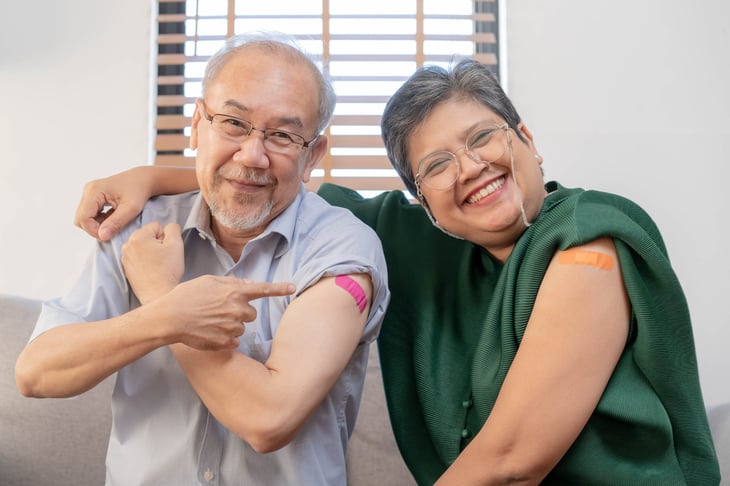 Older adults with band-aids smiling after receiving vaccination