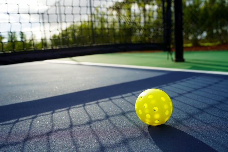 Close up of a pickleball on a pickleball court.