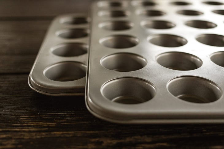 muffin pan on dark wood surface