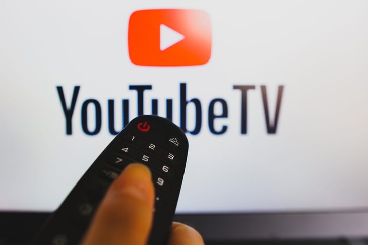 TV remote control seen in front of the YouTube TV logo