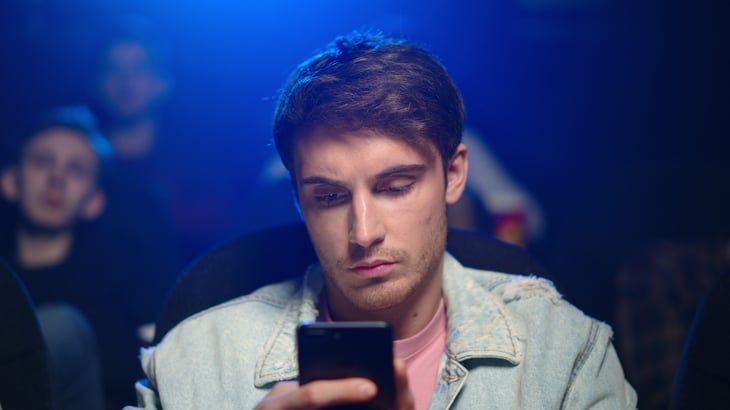 Man on phone in movie theater