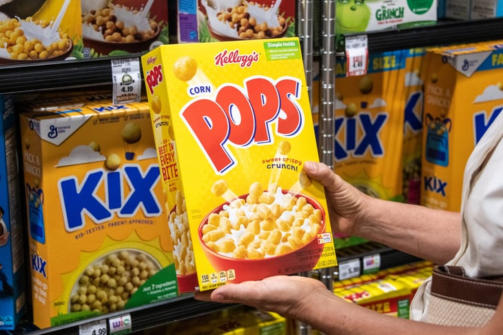 Holding Corn Pops cereal while shopping for groceries at the supermarket