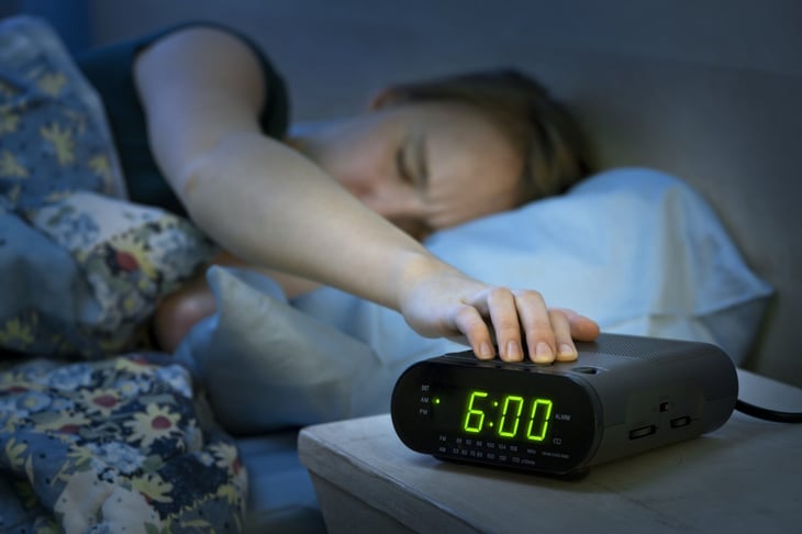 Woman hitting the "snooze" button