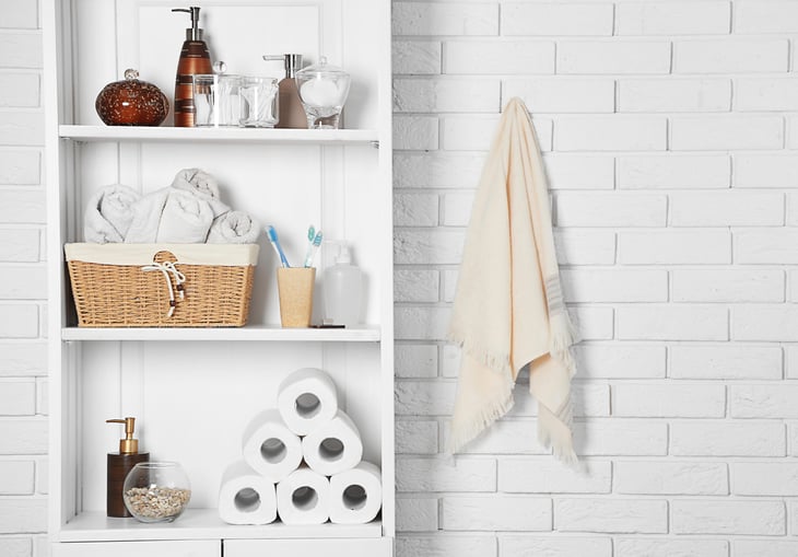 Bathroom shelving with shelves holding toilet paper, towels and toothbrushes