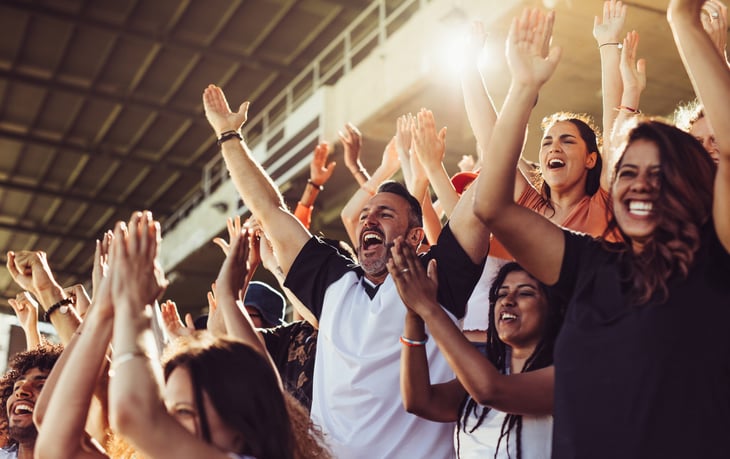 Happy crowd cheering at sports game