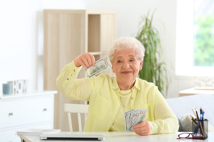 Happy retired woman with money
