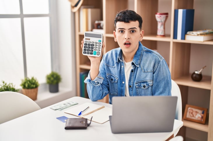 person shocked by budget holding calculator