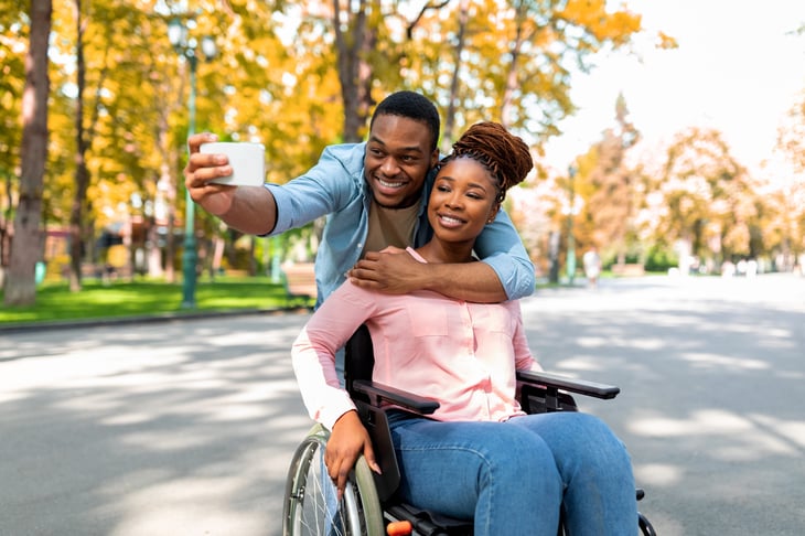 A man hugs his disabled girlfriend who is in a wheelchair