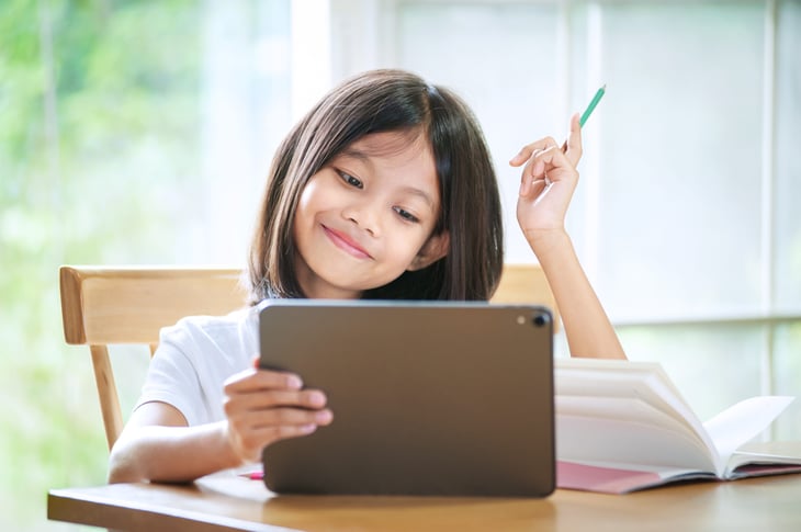 little girl taking classes online