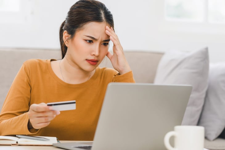 Unhappy young woman with a credit card