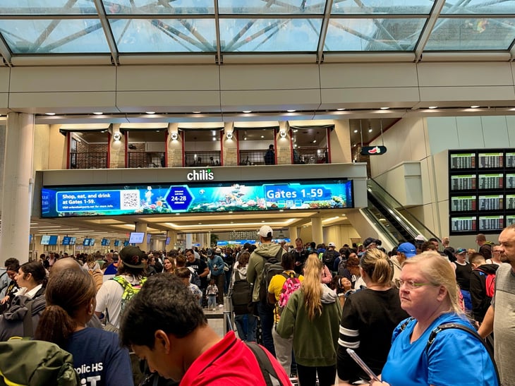 People walking through the busy security line packed with people at the Orlando International Airport (MCO) in Florida.