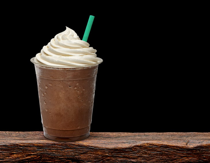 Mocha frappuccino topped with whipped cream in a to-go cup