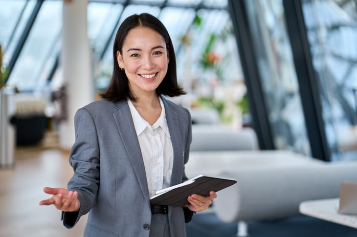 Smiling businesswoman welcomes new employee to a bright open office setting