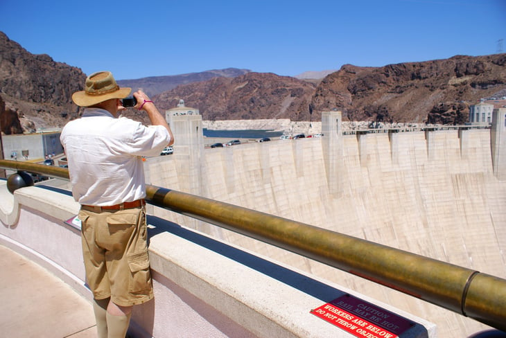 Senior man with camera looking at the Hoover Dam