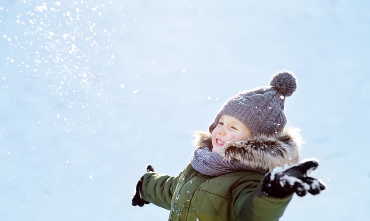 Child playing outdoors in snow