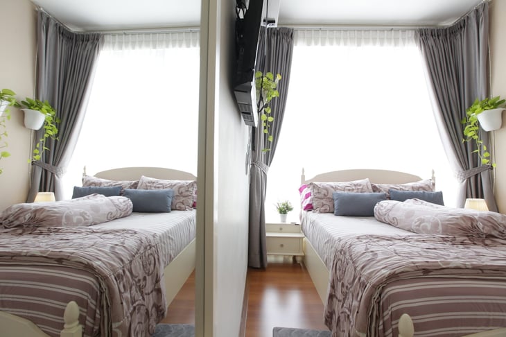 Two beds in a bedroom separated by a wall