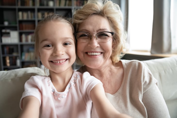 Smiling grandma and granddaughter on a video call or taking a selfie together on a smartphone or laptop