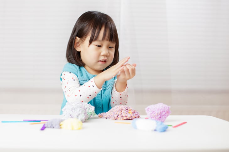 toddler girl playing playfoam at home