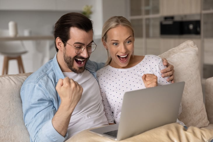 Excited couple looking at a computer