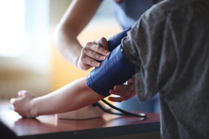 Person putting on a blood pressure cuff