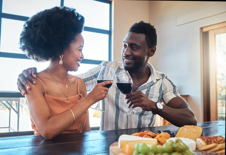 A couple toasts with red wine and a charcuterie plate