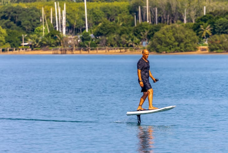 Surfer riding a Fliteboard motorized surfboard