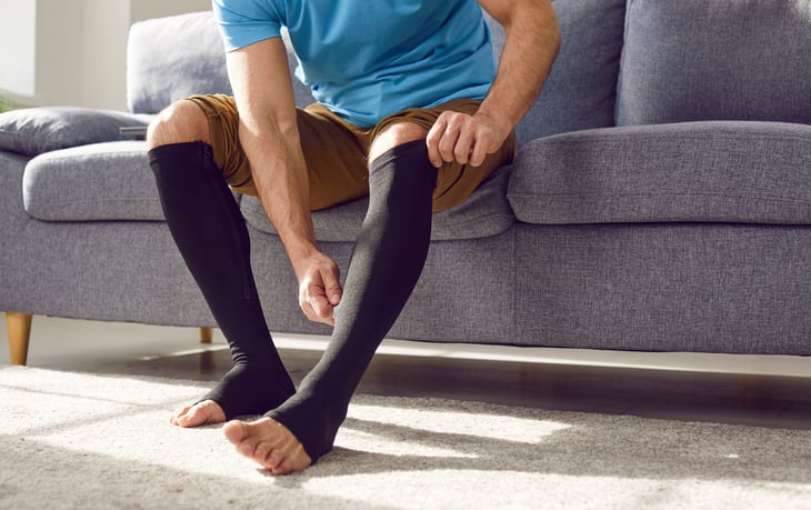 Man putting on compression stockings