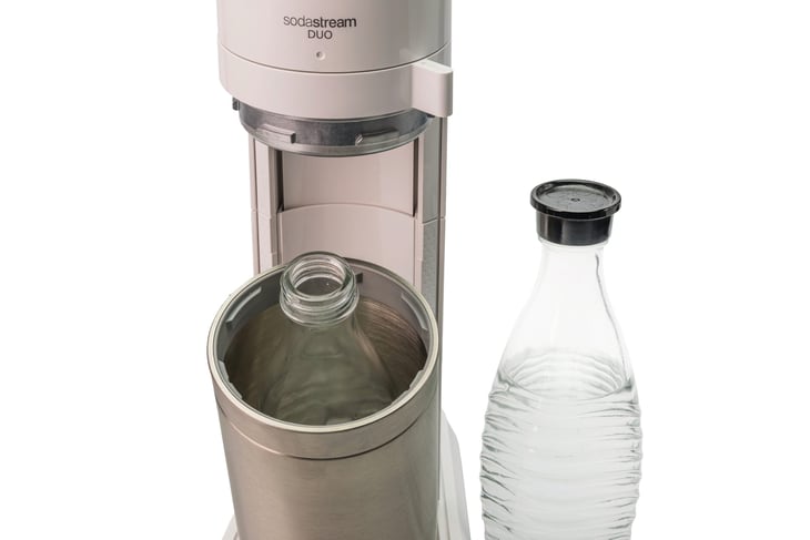 Close-up of SodaStream machine and glass soda bottle