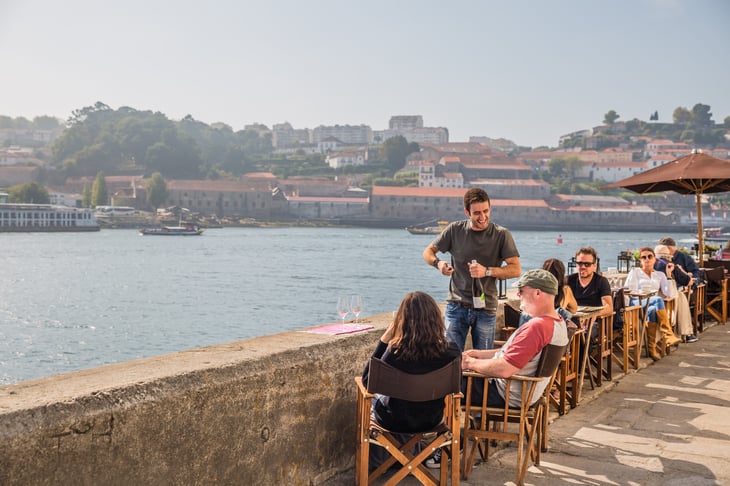 PORTO, PORTUGAL - OCTOBER, 2016: cityscape. view of open-air street cafe on the banks of the River Douro in Porto Portugal