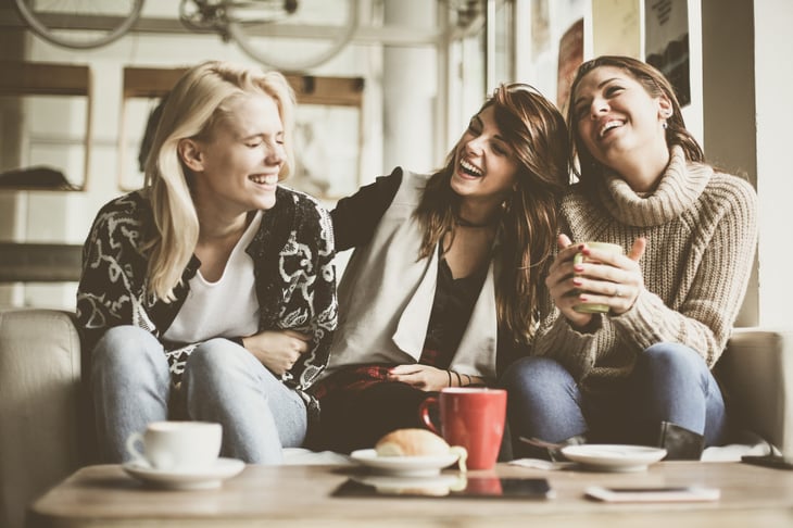 Friends laughing on a sofa