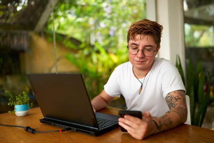Remote worker using a laptop and phone