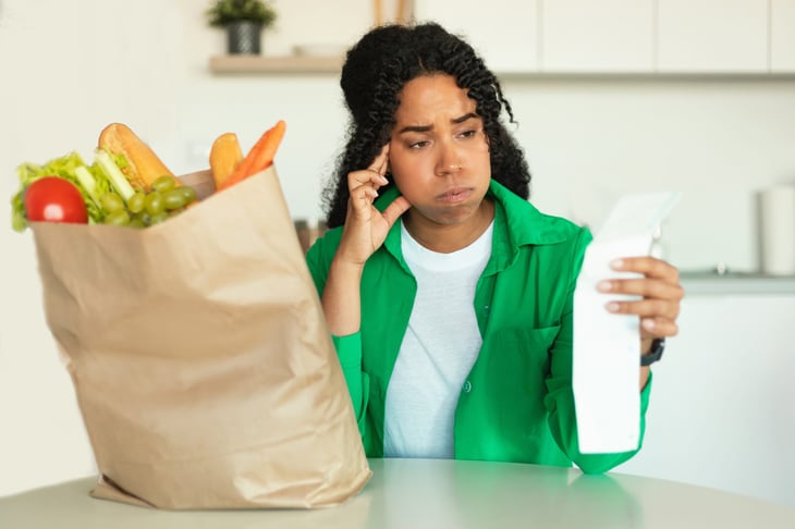 Unhappy woman looking at her grocery bill