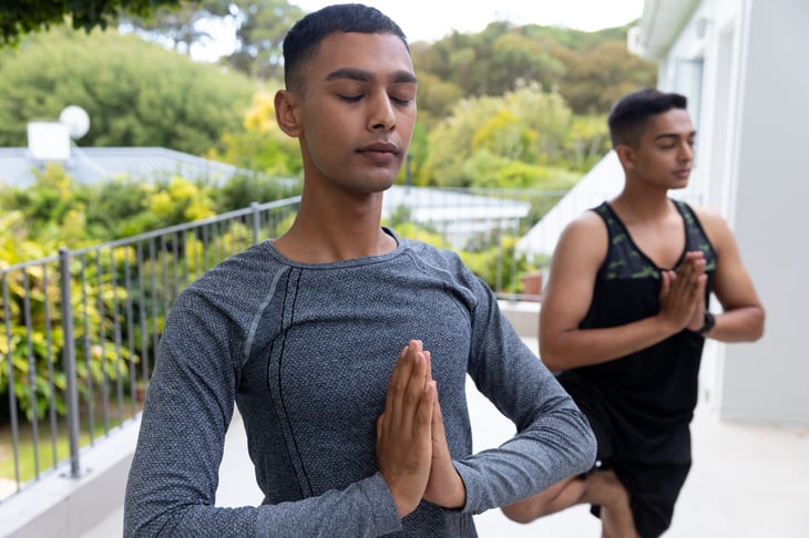 A couple practices yoga outside