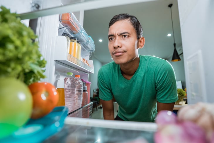 Skeptical man looking into his refrigerator