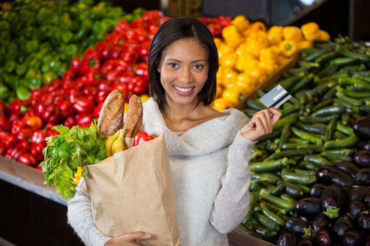 Happy woman shopping in the grocery store.