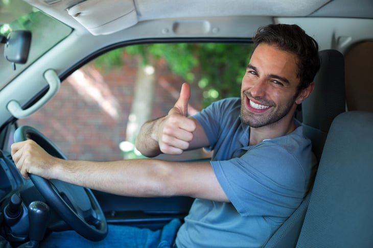 Happy man thumbs up in car