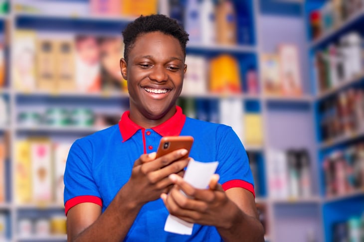 A happy man scans his receipt with his phone