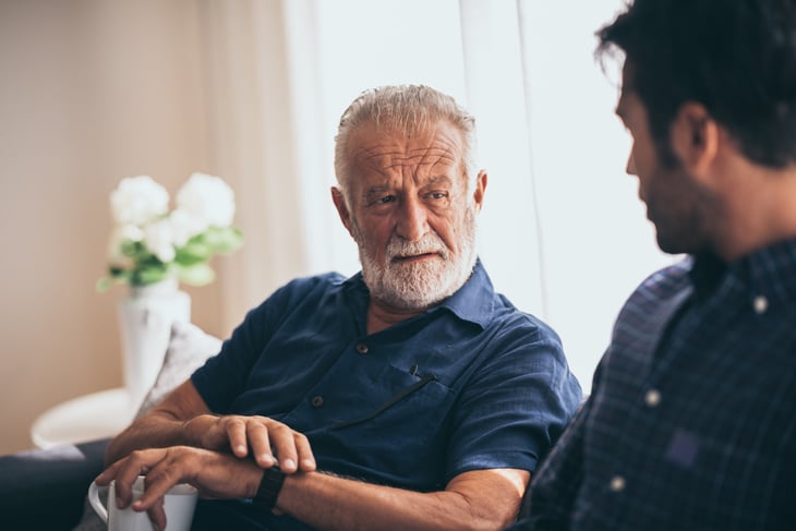 adult child talking to older father