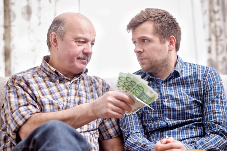 Man giving cash to son