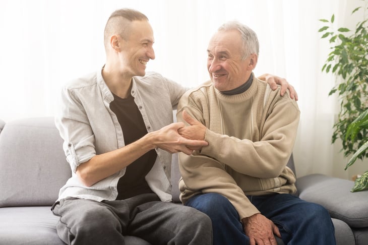 Adult son talking to his senior father and smiling