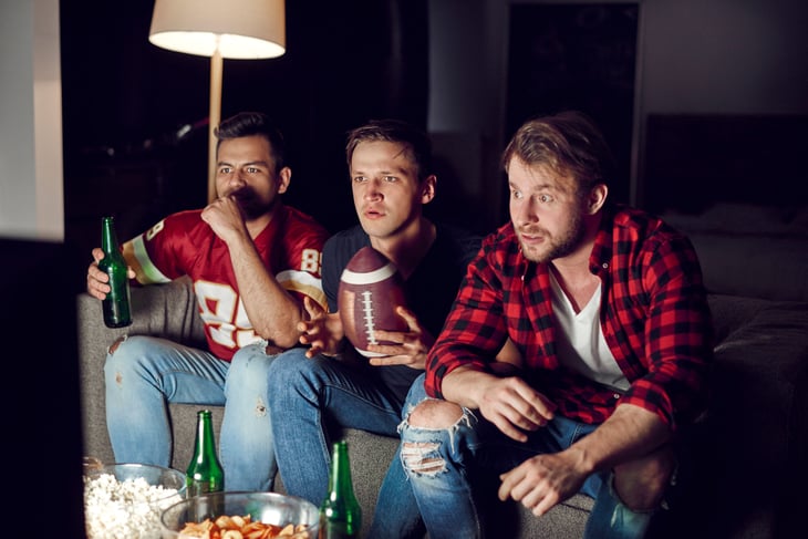 Football fans watching the Super Bowl with beers and snacks